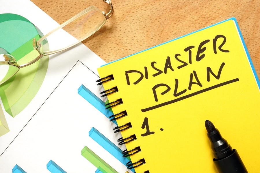 Notepad with disaster plan on a wooden table.